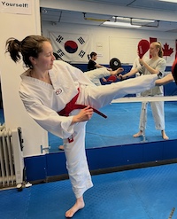 adult taekwondo student turning kick