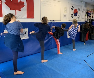 kids taekwondo practicing side kick